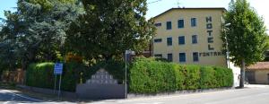 ein Gebäude an der Straßenseite mit einem Schild in der Unterkunft Hotel Fontana in Rubiera