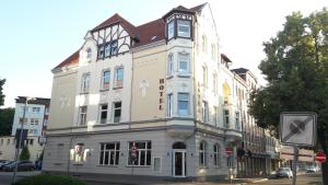 a tall white building on the corner of a street at Hotel An der Altstadt in Hameln