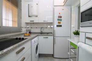 トレモリノスにあるErisa 68 by IVI Real Estateのキッチン(白いキャビネット、冷蔵庫付)