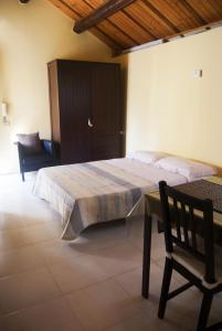 - une chambre avec un lit, une chaise et une table dans l'établissement L'albero delle noci, à Lanciano