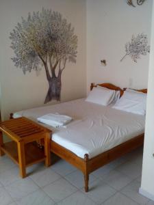 a bedroom with a bed with a tree on the wall at Pansion Matoula in Skiathos