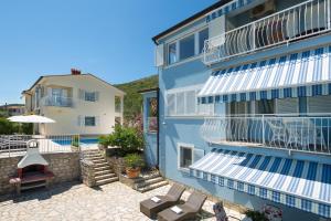 a blue building with white balconies and a patio at Villa Bella Vista - apartments in Labin