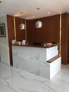 a lobby with a marble counter with two pendant lights at Cebu R Hotel Capitol in Cebu City