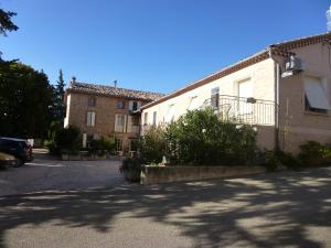 a building with a parking lot in front of it at Les Gites du Mont Ventoux in Bédoin