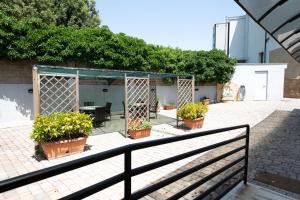 eine Terrasse mit Topfpflanzen und einem Zaun in der Unterkunft Cervara Park Hotel in Rom