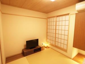 a room with a flat screen tv in the corner at harper house in Osaka