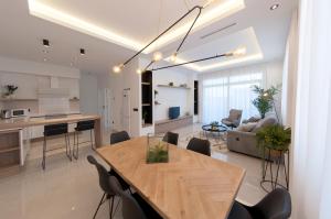 uma cozinha e sala de estar com uma mesa de madeira e cadeiras em Apartamentos La Laguna II Luxury Apartments em Ciudad Quesada