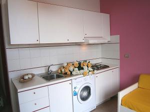 a kitchen with a washing machine and a sink at Biloba in Bibione