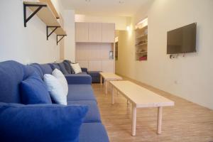 a living room with a blue couch and a table at Stay Liuqiu Diving Hostel in Xiaoliuqiu