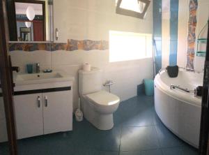 a bathroom with a toilet and a sink and a tub at Guest House Guriani in Grigoleti