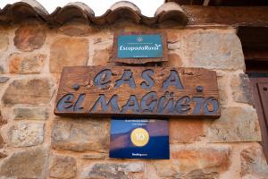 ein Schild an der Seite eines Steingebäudes in der Unterkunft Casa Magüeto in Combarros