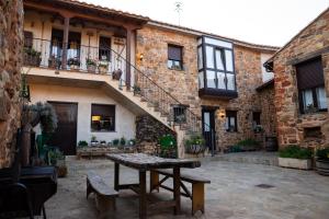 a stone courtyard with a table in front of a building at Casa Magüeto in Combarros