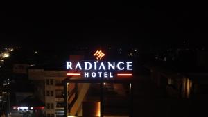 a sign for a radiance hotel at night at Hotel Radiance in Ahmadnagar
