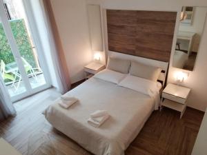 - une chambre avec un grand lit blanc et 2 tables dans l'établissement Il Tesoro di SanGennaro, à Naples