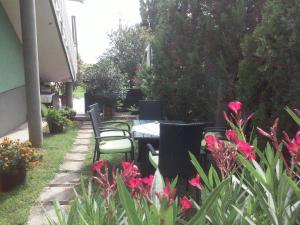 バラトンギュルクにあるHoldfény Apartmanの花の咲く庭園のテーブルと椅子