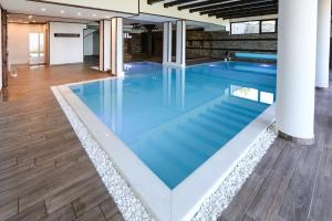 - une grande piscine d'eau bleue dans un bâtiment dans l'établissement Hotel Leshten, à Leshten