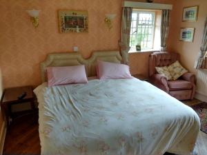 a bedroom with a large bed and a chair at Thornley House in Hexham