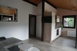 a living room with a couch and a kitchen at Ferienhaus an der Lister in Windebruch +18 photos