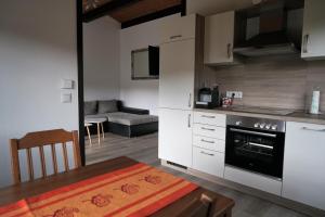 a kitchen with white cabinets and a table and a couch at Ferienhaus an der Lister in Windebruch