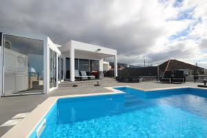 a house with a swimming pool and a patio at Villa Por do Sol in Estreito da Calheta