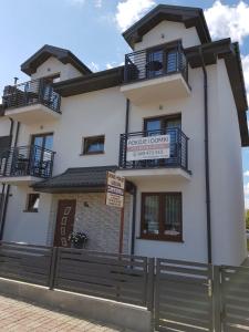 a white house with a black fence at "Sevach" Ustronie Morskie in Ustronie Morskie