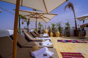 a lounge area with chairs, tables and umbrellas at Riad Jemaa El Fna & Spa in Marrakesh