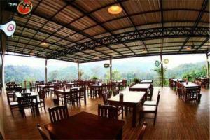 um restaurante com mesas e cadeiras e vista para as montanhas em Sangkla Resort em Ban Sane Phong