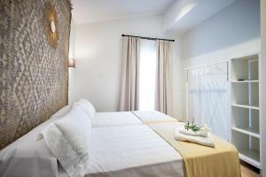 a bedroom with a white bed and a window at Casagrande - La Barrosa in Chiclana de la Frontera