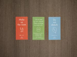 four different colored signs on a wooden door at THE KNOT TOKYO Shinjuku in Tokyo