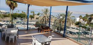 a balcony with tables and chairs and a view of the ocean at Atara Hotel in Tiberias