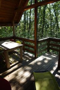 a wooden deck with a table and a bench on it at La Cabane aux Rêves in Sepx