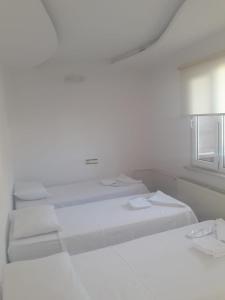 a white room with two beds and a window at Çavdar Thermal Hotel in Pamukkale