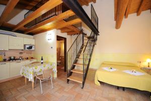 a kitchen and a living room with a staircase in a house at Agriturismo Lizzarola in Peschiera del Garda