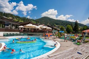 un grupo de personas en una piscina en un complejo en Apartments Dolomie, en Ortisei