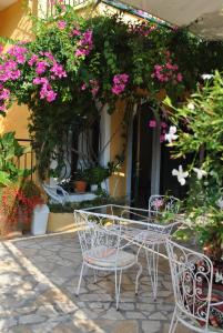 een tafel en stoelen voor een gebouw met bloemen bij Hotel Helios Splendid in Boukari