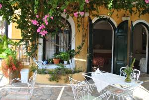 a table and chairs in front of a building with flowers at Hotel Helios Splendid in Boukari