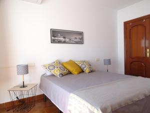 a bedroom with a large bed with yellow pillows at Atico La Luz : Centre ville, rénové, terrasse in Salobreña