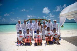 a group of people standing on a beach at Biyadhoo Island Resort in Biyadhoo