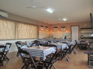 a dining room with tables and chairs in it at Pousada Quinta Das Aroeiras in Olímpia