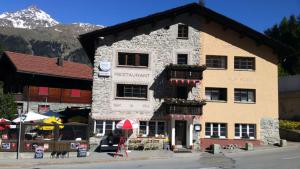 un grand bâtiment en pierre avec un marché en face dans l'établissement Hotel Restaurant Edelweiss, à Mühlen