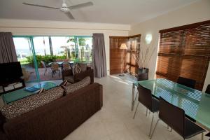 salon z kanapą i stołem w obiekcie Coral Sands Beachfront Resort w mieście Trinity Beach
