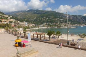 a group of people walking on a beach near the water at Residence Albert Premier in Menton