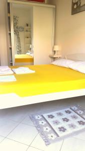 ein Schlafzimmer mit einem großen gelben Bett und einem Spiegel in der Unterkunft Apartmani Dačo in Sveti Stefan