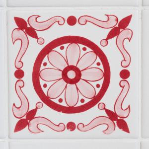 a red and white tile with a flower on it at La Sentinella Holiday House in Bracciano