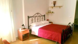 una camera con letto e piumone rosso di Benvenuti al Massimo a Palermo