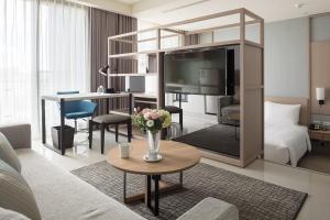 uma sala de estar com uma cama e um vaso de flores em Jolley Hotel em Taipei