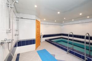 a bathroom with a swimming pool and a shower at Hotel Belalakaya in Dombay