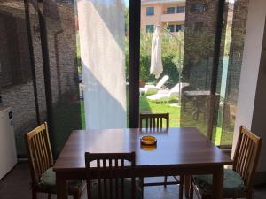 a wooden table and chairs with a view of a patio at Casale Pratoterra in Bracciano