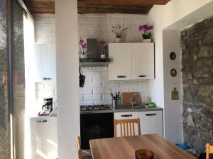 a kitchen with white cabinets and a wooden table at Casale Pratoterra in Bracciano