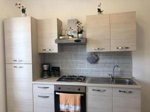 La cuisine est équipée de placards en bois et d'un four avec plaques de cuisson. dans l'établissement CASALE PRATOTERRA 2, à Bracciano